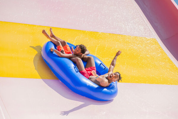 The Wall tube slide with two brothers riding up the incline. Feature image for outdoor waterpark page for reference.