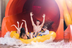 family in a giant tube at the end of the slide