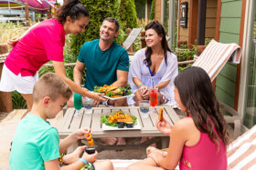 family being served food at an outdoor cabana