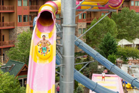 dad and daughter descending down the wall outdoor waterslide