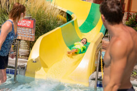 child sliding down a body slide at lake wilderness