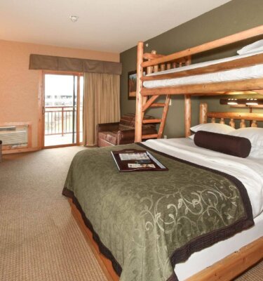 A room with bunk beds, a balcony, and a double bed.