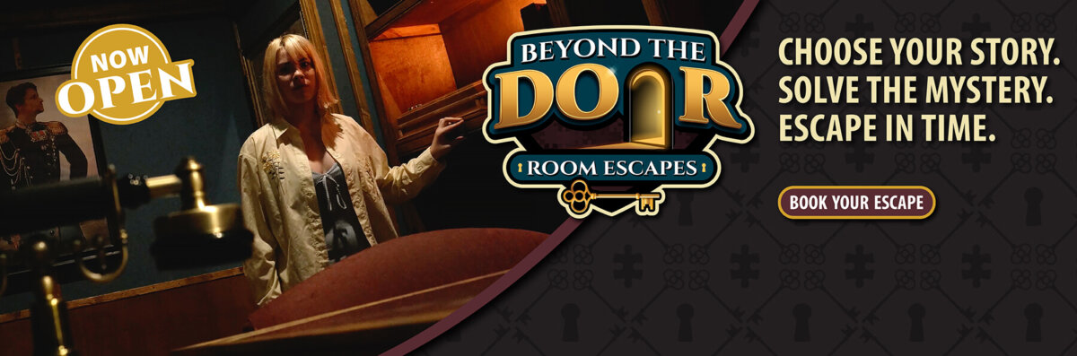 Promotional banner for Beyond the Door Room Escapes featuring a woman inside a dimly lit mystery room with text reading “Choose Your Story. Solve the Mystery. Escape in Time.” and “Now Open”
