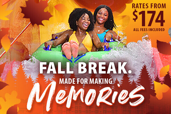 Two women laugh as they ride a green inner tube down a water slide, beside text promoting a fall break getaway: “Made for making memories. Rates from $174, all fees included.”